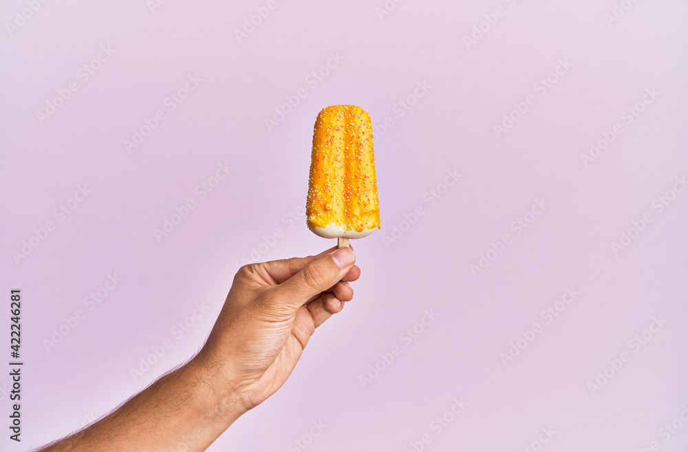 Hand of hispanic man holding ice cream over isolated pink background. Hand of hispanic man holding ice cream over isolated pink background.