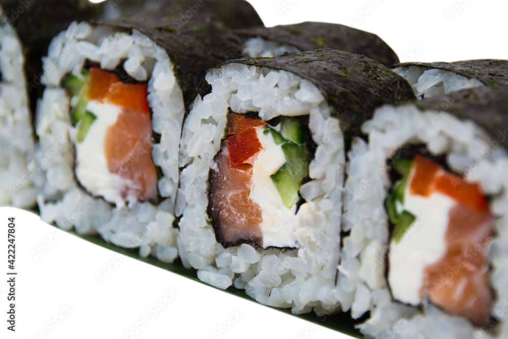 Rolls with nori, rice, cream cheese, salmon and cucumber on a white plate close up Rolls with nori, rice, cream cheese, salmon and cucumber on a white plate close up