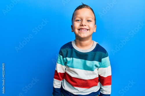 Little kid boy wearing striped sweater with a happy and cool smile on face. lucky person.