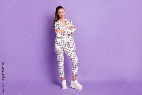Full length photo of attractive confident young woman hold arms crossed smile isolated on violet color background