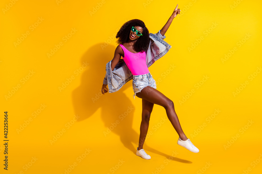 Full body photo of charming afro american woman point finger dance disco isolated on yellow color background Full body photo of charming afro american woman point finger dance disco isolated on yellow color background