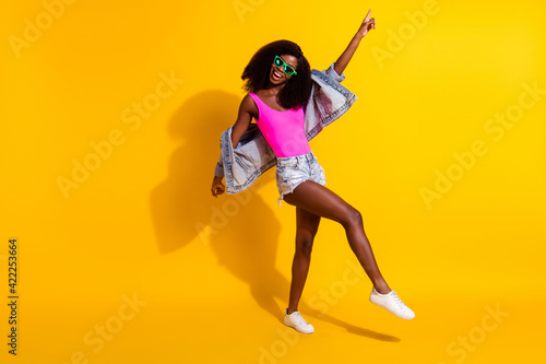 Full body photo of charming afro american woman point finger dance disco isolated on yellow color background