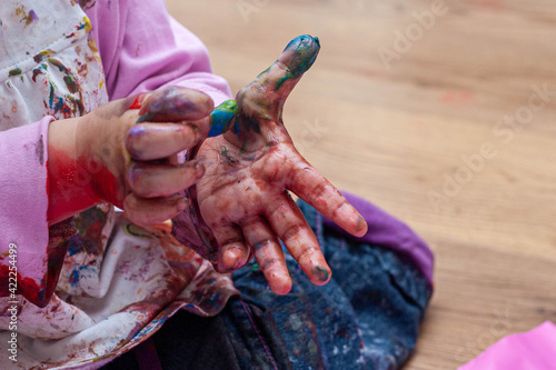 Child picking at paint on hands