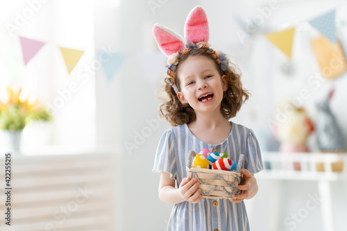 child with Easter painting eggs
