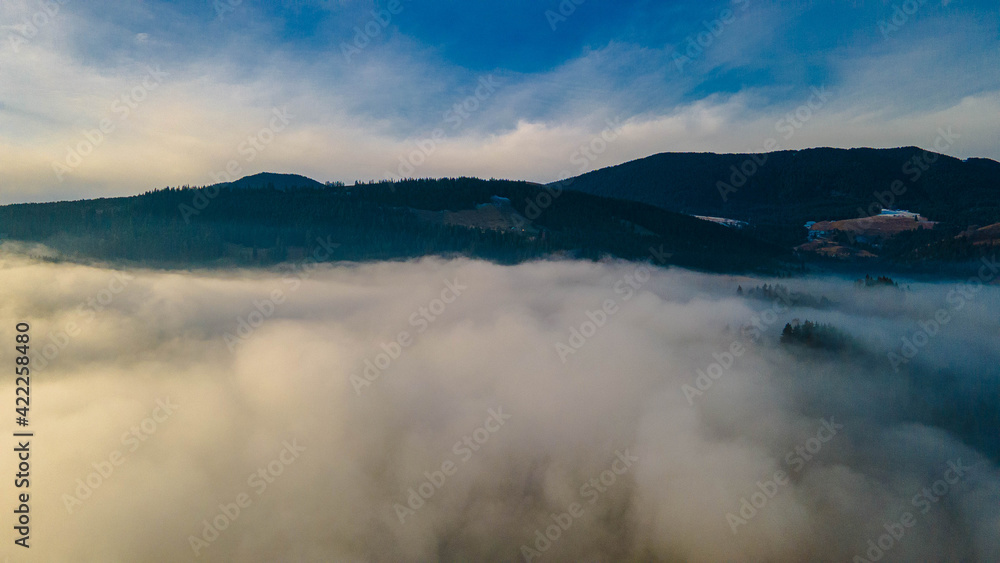 Obraz premium mountains tops high above clouds fog