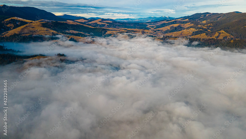Obraz premium mountains tops high above clouds fog