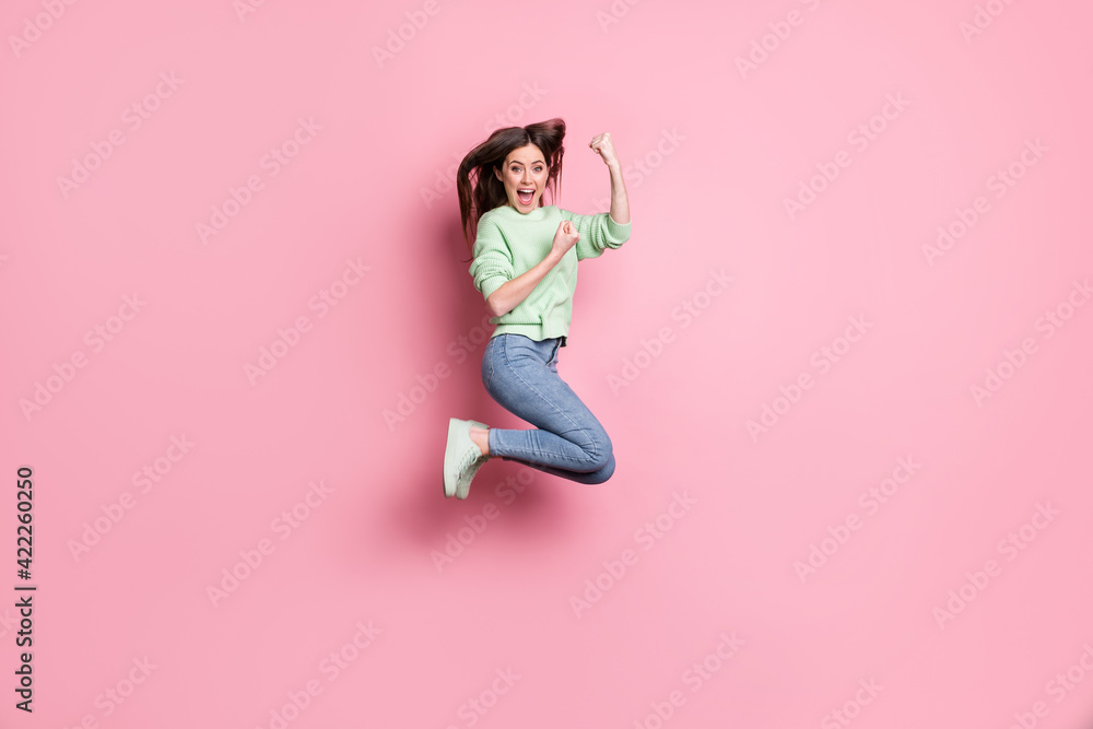 Full size profile photo of brunette girl yell jump wear lime sweater jeans sneakers isolated on pink color background Full size profile photo of brunette girl yell jump wear lime sweater jeans sneakers isolated on pink color background