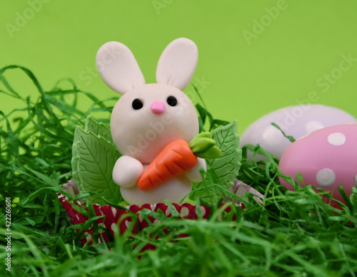 Cute easter baby bunny toy on a green background stock images. Easter decoration with cute little rabbit and polka dot eggs images. Easter animal figurine still life stock photo © betka82