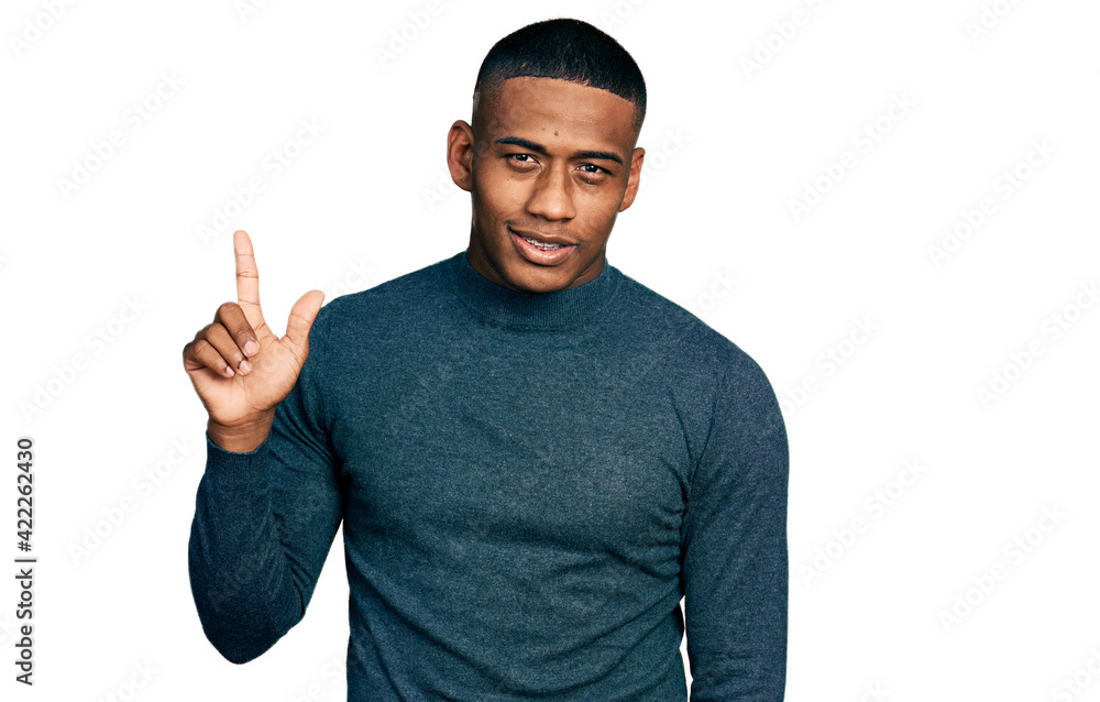 Young black man wearing casual sweater smiling with an idea or question pointing finger up with happy face, number one Young black man wearing casual sweater smiling with an idea or question pointing finger up with happy face, number one