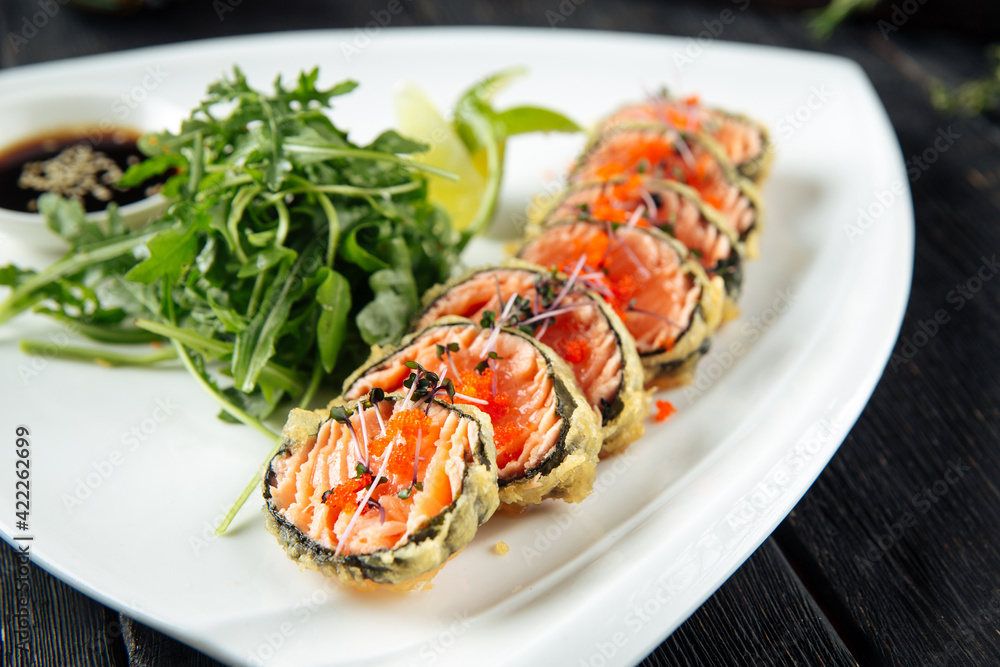 Closeup on asian fried salmon rolls with arugula and soy sauce Closeup on asian fried salmon rolls with arugula and soy sauce