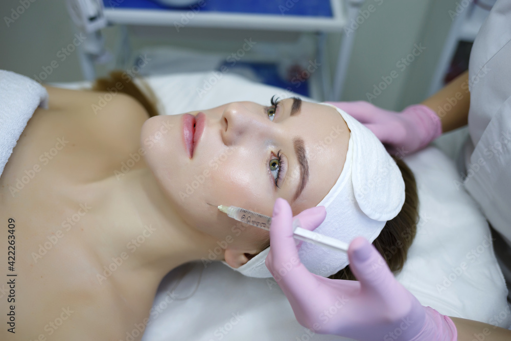 Cosmetologist does injections anti wrinkle of a beautiful woman. Women s cosmetology in the beauty salon.