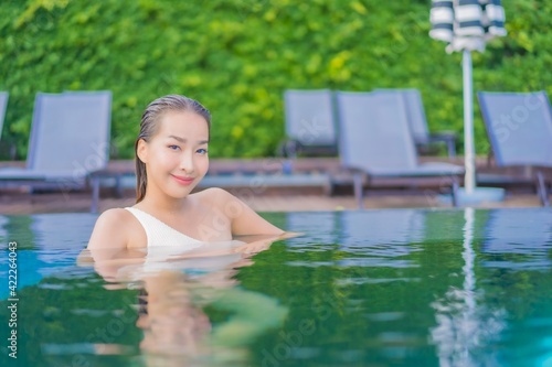 Portrait beautiful young asian woman enjoy around outdoor swimming pool with sea view
