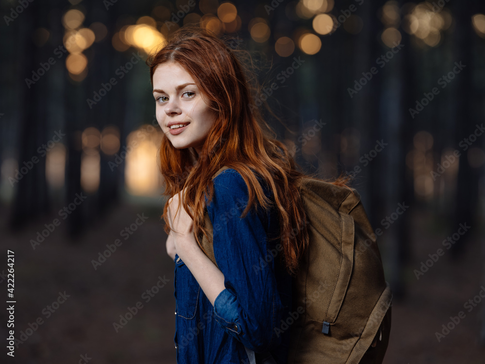 Fototapeta premium Happy woman travels among pine trees in nature in the forest