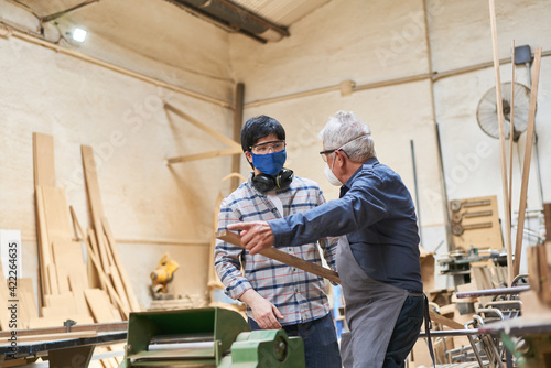 Handwerker Senior und Lehrling in Ausbildung in Werkstatt