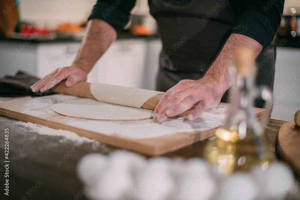 A male chef prepares noodles at home in the kitchen. A male chef prepares noodles at home in the kitchen.