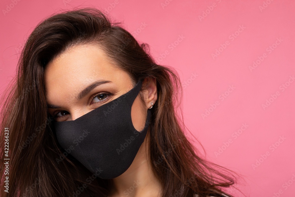 Shot of young attractive woman wearing mediacal face mask isolated over background wall. Protection against COVID-19 Shot of young attractive woman wearing mediacal face mask isolated over background wall. Protection against COVID-19