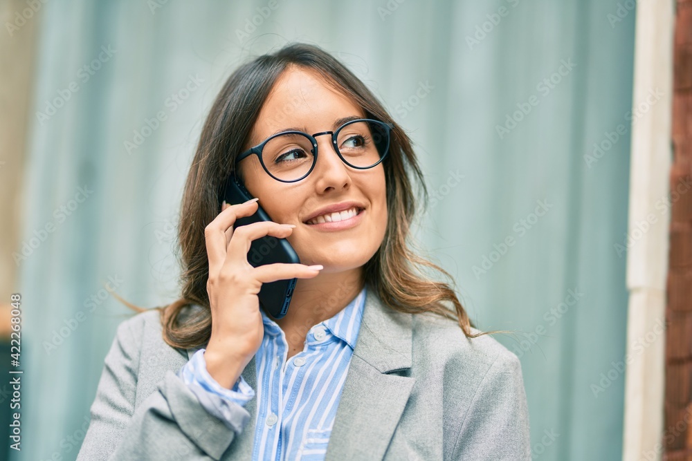 Young hispanic businesswoman smiling happy tlking on the smartphone at the city. Young hispanic businesswoman smiling happy tlking on the smartphone at the city.