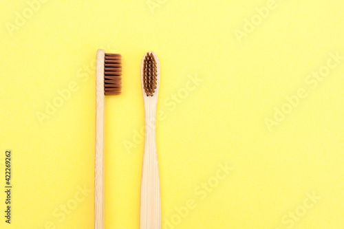 Bamboo toothbrush on a yellow background. Dental care. Taking care of the world around you. 