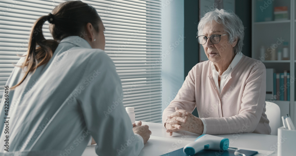 Naklejka premium Caring doctor assisting a senior patient