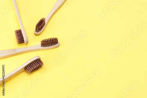 Bamboo toothbrush on a yellow background. Dental care. Top view, space for text. © Юлия Васильева