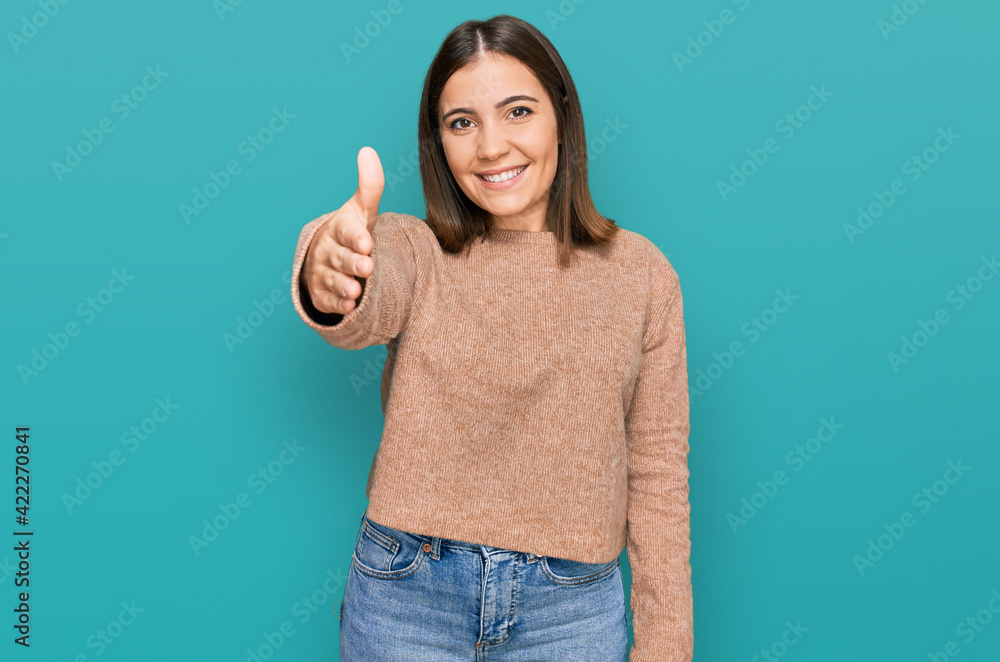 Young beautiful woman wearing casual clothes smiling friendly offering handshake as greeting and welcoming. successful business. Young beautiful woman wearing casual clothes smiling friendly offering handshake as greeting and welcoming. successful business.