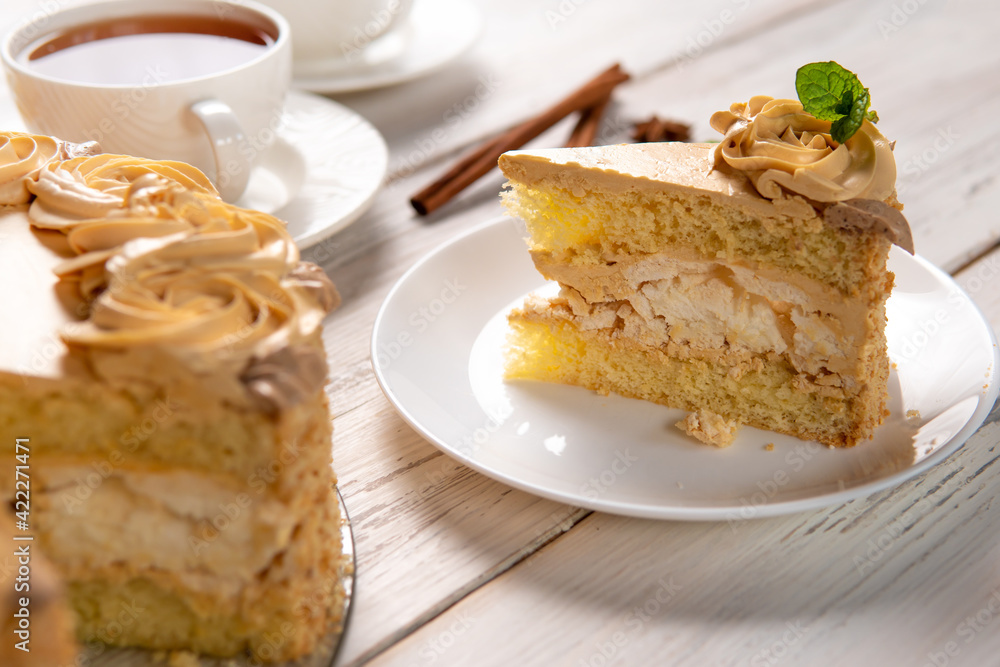 A piece of cake on a plate on a white wooden background A piece of cake on a plate on a white wooden background