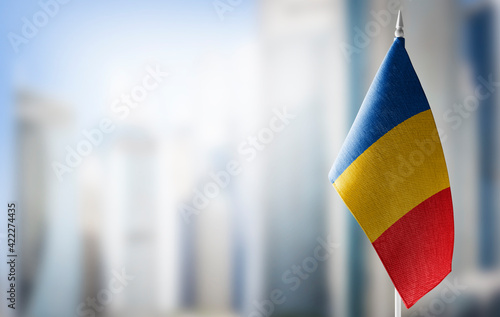 A small flag of Chad on the background of a blurred background