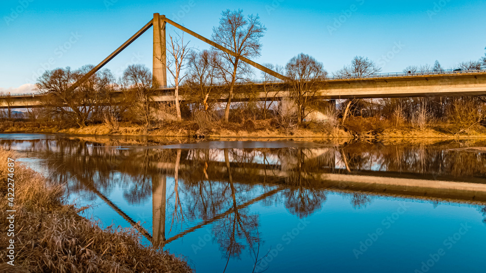 Beautiful autumn or indian summer view with reflections and a highway bridge near Mettenufer, Danube, Bavaria, Germany