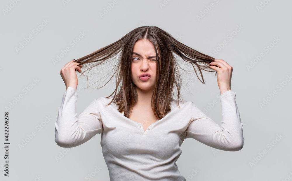 Frustrated woman having a bad hair. Woman having a bad hair, her hair is messy and tangled. Messy hair. Brunette woman with messed hairs. Girl having a bad hair. Bad hairs day Frustrated woman having a bad hair. Woman having a bad hair, her hair is messy and tangled. Messy hair. Brunette woman with messed hairs. Girl having a bad hair. Bad hairs day