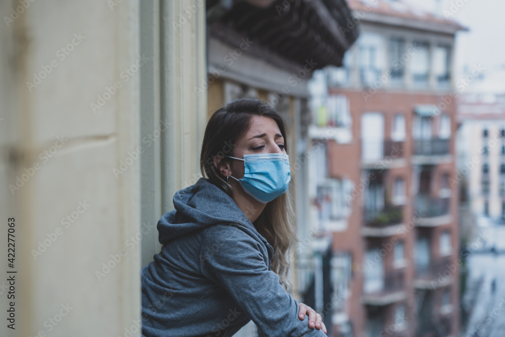 Young beautiful unhappy woman with face mask suffering from depression due to isolation Young beautiful unhappy woman with face mask suffering from depression due to isolation