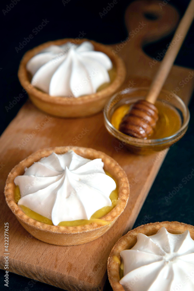 lemon tartlet with cream on a dark background. lemon tartlet with cream on a dark background.