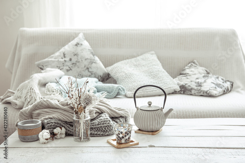 A teapot with details of hygge decor on the table in the living room. photo