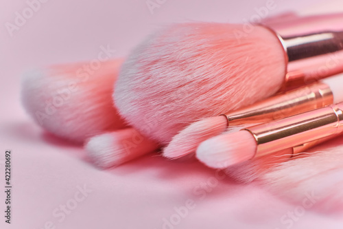 pink makeup brushes on a pink background