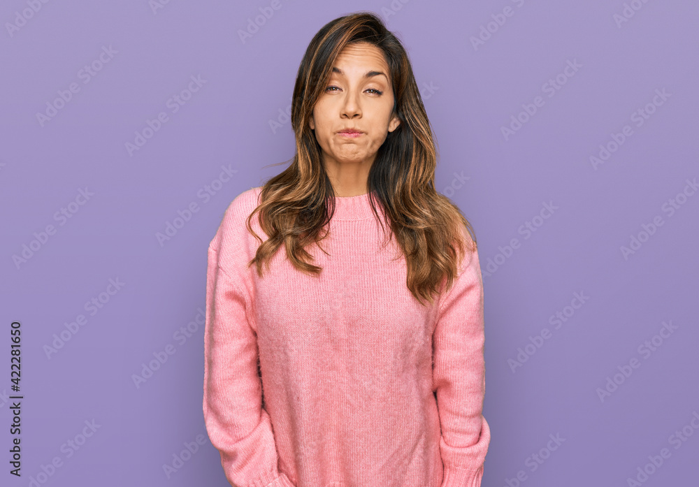 Fototapeta premium Young hispanic woman wearing casual clothes puffing cheeks with funny face. mouth inflated with air, crazy expression.