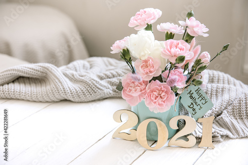 Cozy spring still life with fresh flowers and decorative number 2021 for mother's day. photo