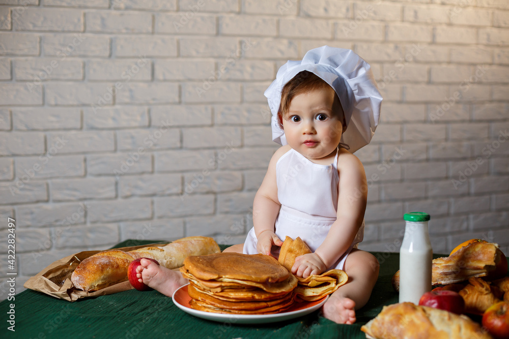 Little chef. Little kid dressed as a chef with pastries, buns, bread Little chef. Little kid dressed as a chef with pastries, buns, bread