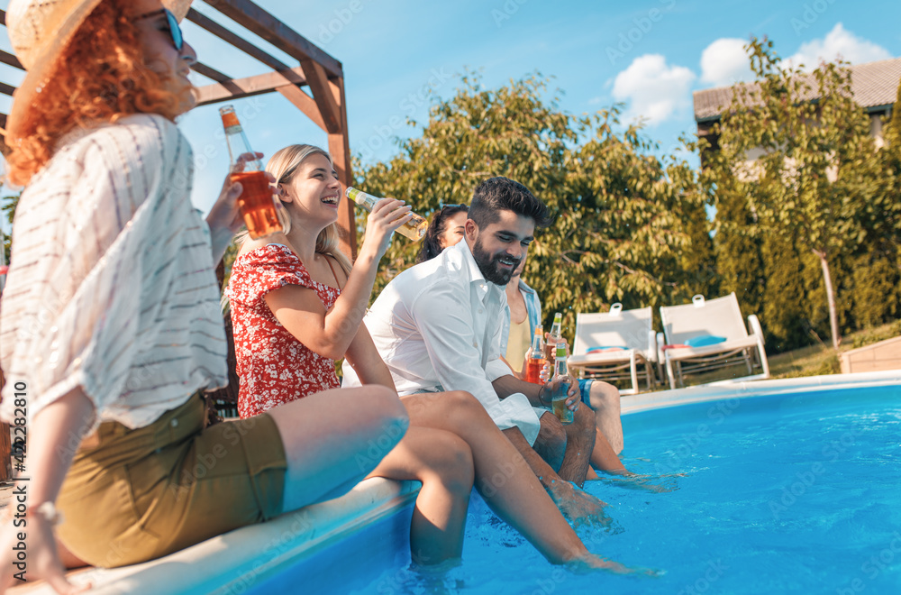 Group of friends having fun at summer vacation enjoying at poolside party.