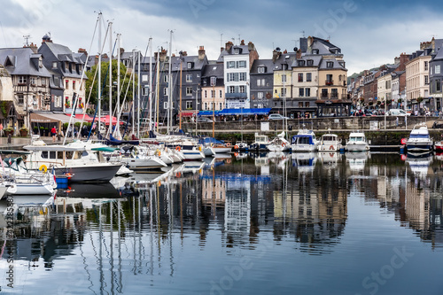 Honfleur, Normandy / France - August 27, 2020. World heritage in Calvados, Normandy, France. Panoramic view of the picturesque harbour of Honfleur, yachts and old houses reflected in water. © Anna