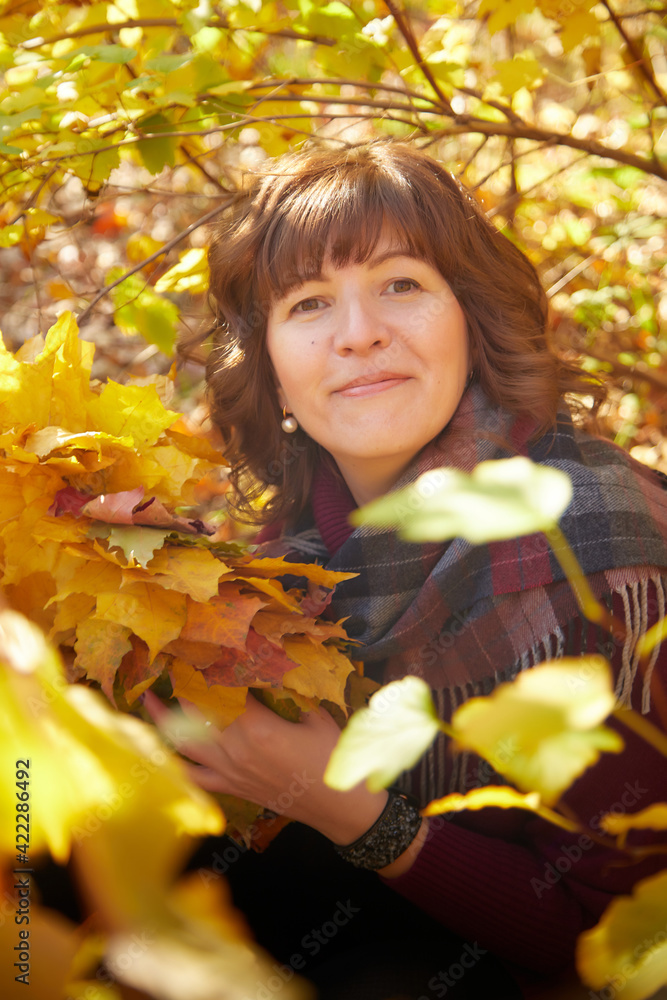 Portrait of mature woman in autumn park and trees with yellow leaves background Portrait of mature woman in autumn park and trees with yellow leaves background