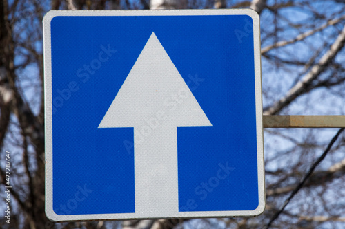 street road sign white arrow on a blue square. one-way traffic. traffic rules