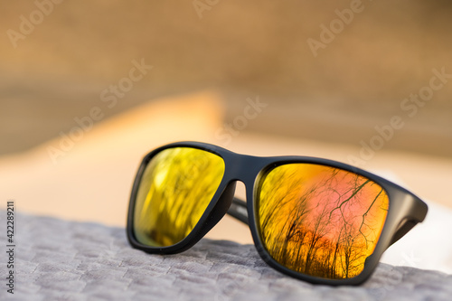 Classic Sunglasses design with golden lenses shoot outside in a summer day closeup. Selective focus. High quality photo
