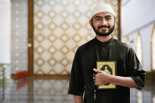 Canvas Print Religious asian muslim man holding holy quran
