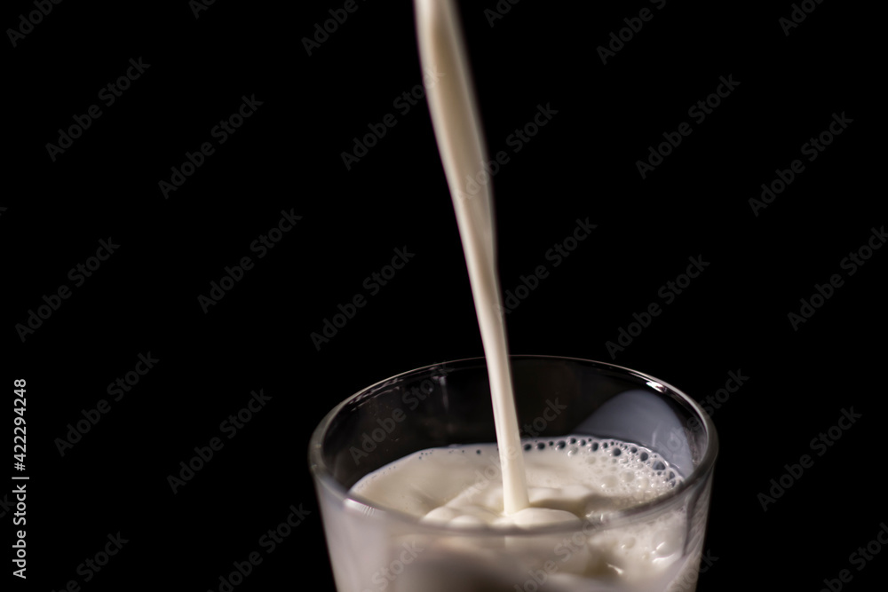 pouring milk in a glass. splash of white liquid isolated on dark background pouring milk in a glass. splash of white liquid isolated on dark background