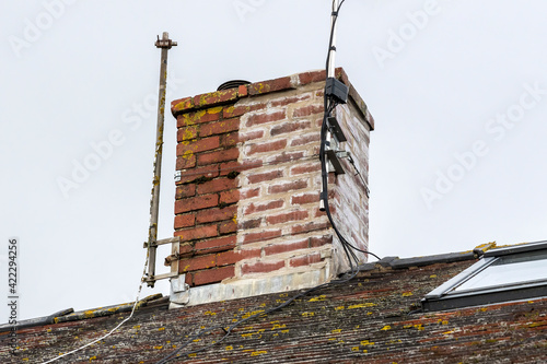 Fotografia Chimney stack on a house roof, partly weather sealed and repaired with a recent
