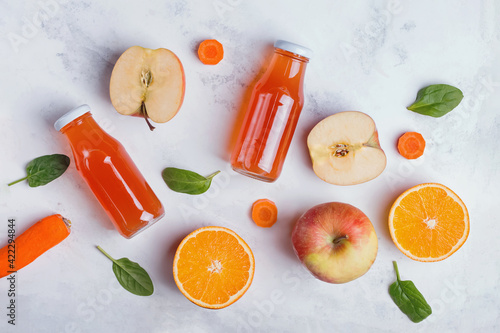 Healthy fruit juices, apples and oranges on white table, top view.