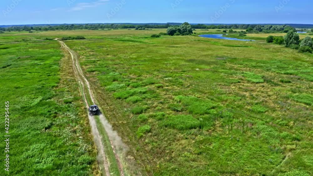 Aerial view from drone which is pursuit a rally car going in cross country space. Fast buggy is going with big clouds of dust. Top view from drone onto race with buggies. Aerial view from drone which is pursuit a rally car going in cross country space. Fast buggy is going with big clouds of dust. Top view from drone onto race with buggies.