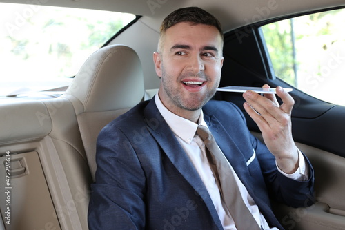Businessman recording audio message in taxi © ajr_images