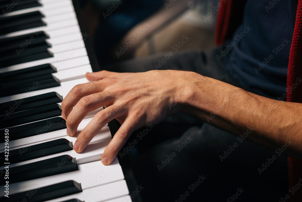 Top view of unrecognizable musician man playing on synthesize at home studio during lesson. Close-up hands of pianist male playing on digital piano in living room. Concept of music education. Top view of unrecognizable musician man playing on synthesize at home studio during lesson. Close-up hands of pianist male playing on digital piano in living room. Concept of music education.