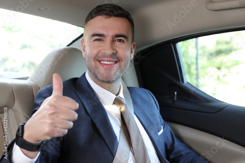 Businessman giving thumbs up in taxi © ajr_images