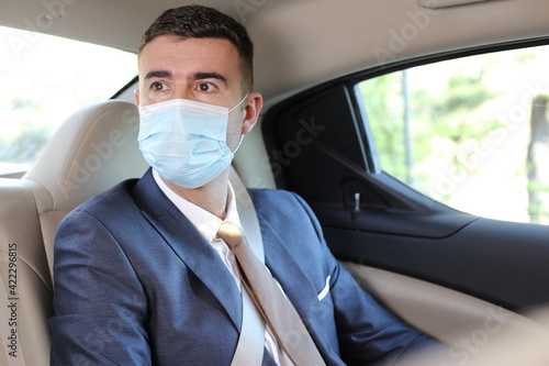 Businessman using taxi with protective mask